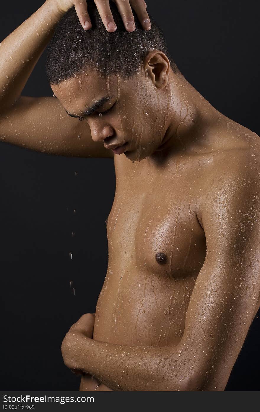 Drops of the water on naked body of a young man on black background. Drops of the water on naked body of a young man on black background.