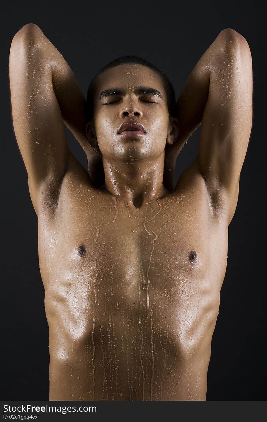 Drops of the water on naked body of a young man on black background. Drops of the water on naked body of a young man on black background.