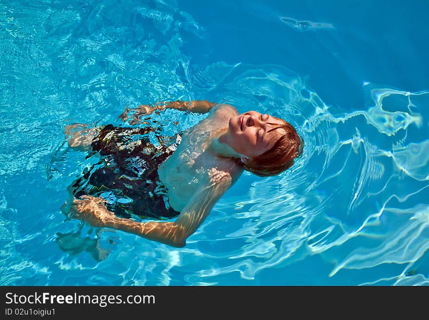 Child has fun swimming in the pool. Child has fun swimming in the pool