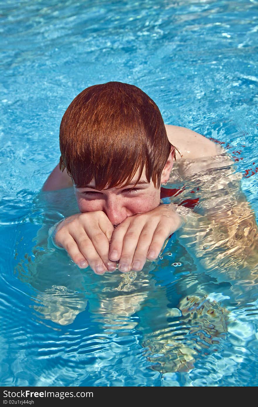 Young boy plays with his hands in the water and imitates a crocodile. Young boy plays with his hands in the water and imitates a crocodile