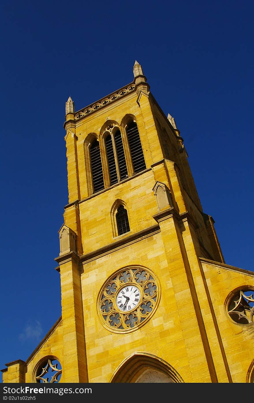 Yellow limestone church of roanne against blue sky in france