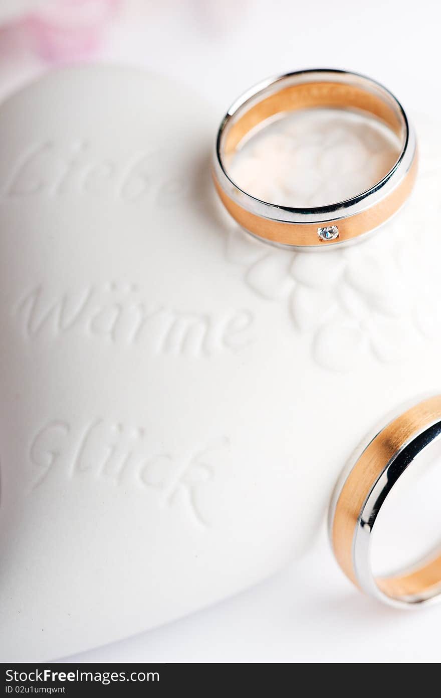 Two wedding rings with flowers in the background