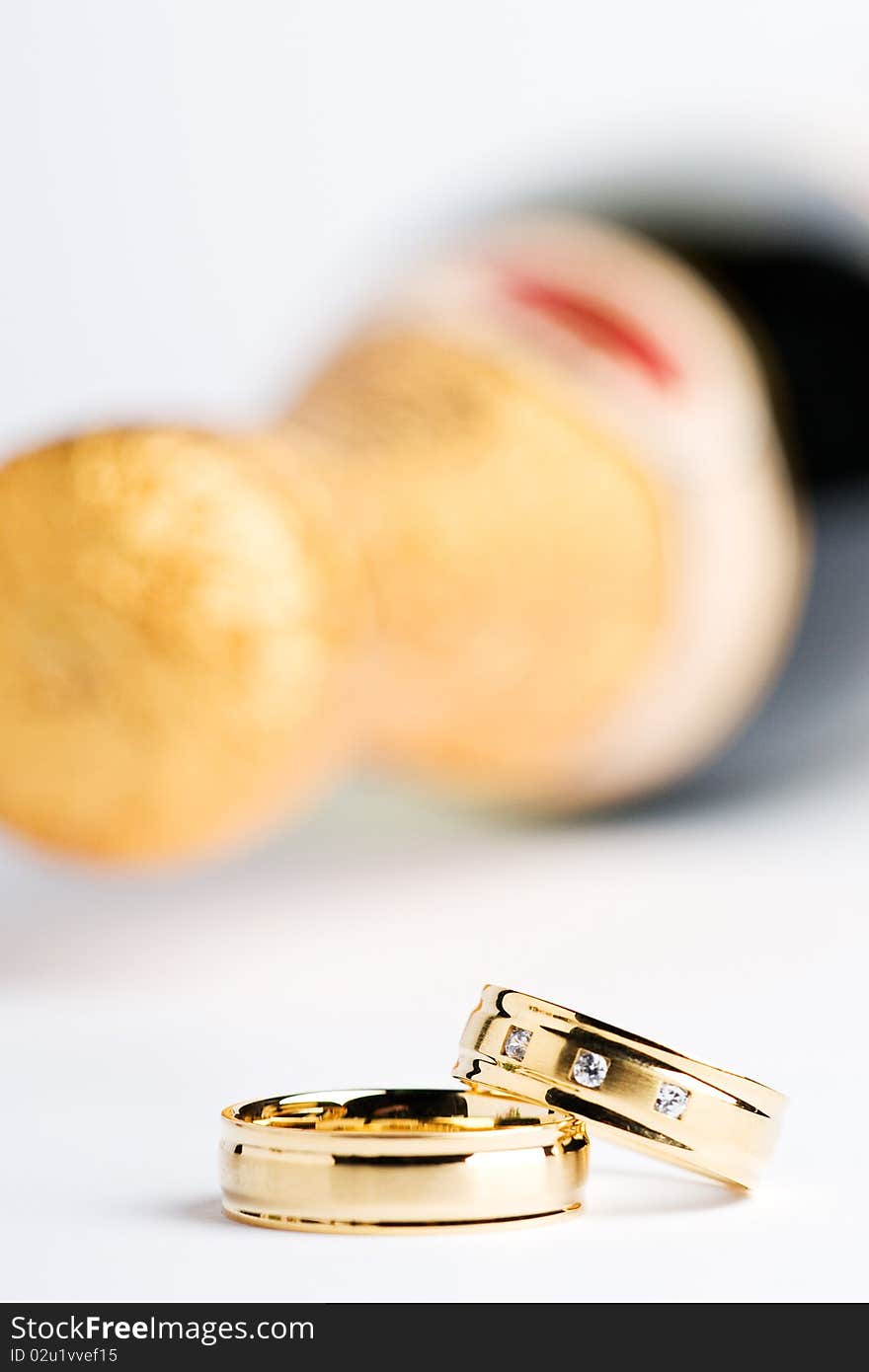 Two wedding rings with a bottle champagner in the back