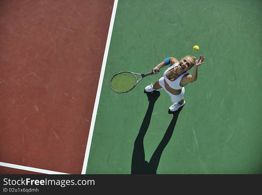 Young fit woman play tennis outdoor on orange tennis field at early morning. Young fit woman play tennis outdoor on orange tennis field at early morning