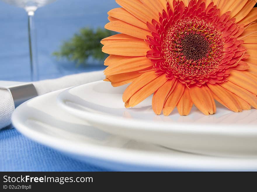 Orange flower and white plates with napkin. Orange flower and white plates with napkin