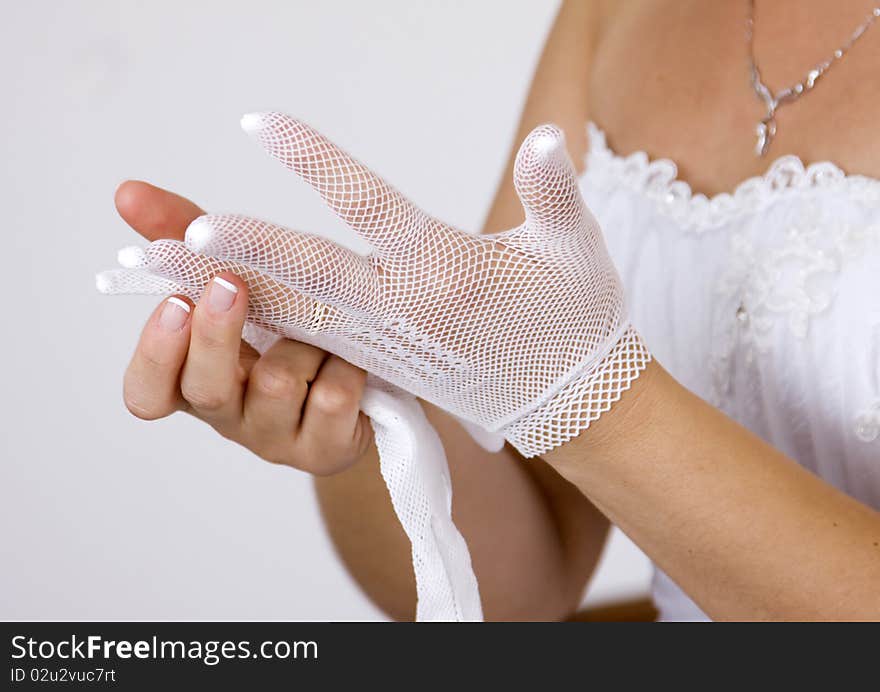 Bride putting on her white gloves. Bride putting on her white gloves