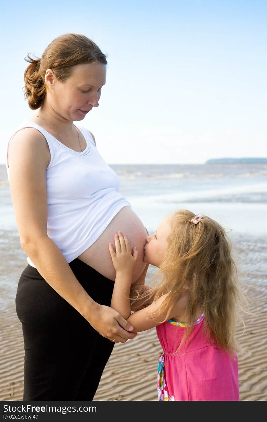 Daughter on the beach obnmaet pregnant mother.Mother and daughter