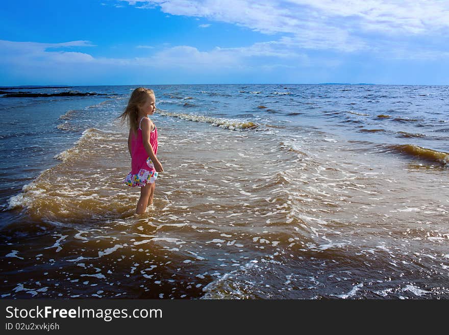 The little girl igret water on the beach. The little girl igret water on the beach.