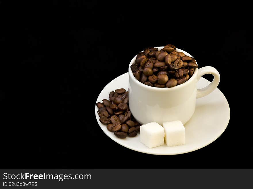 White cup with coffee beans and sugar