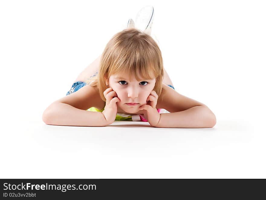 Cute little girl lie on the floor. Studio shot