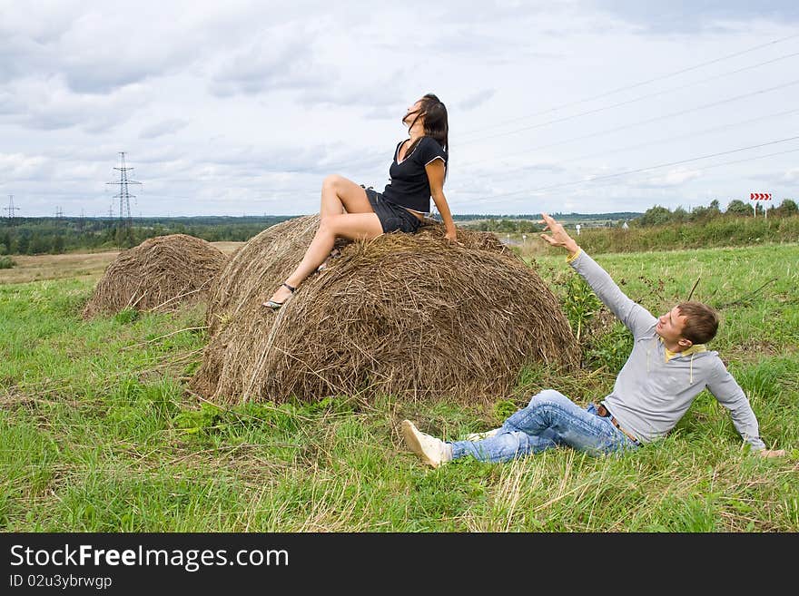 Young couple costs about a haystack