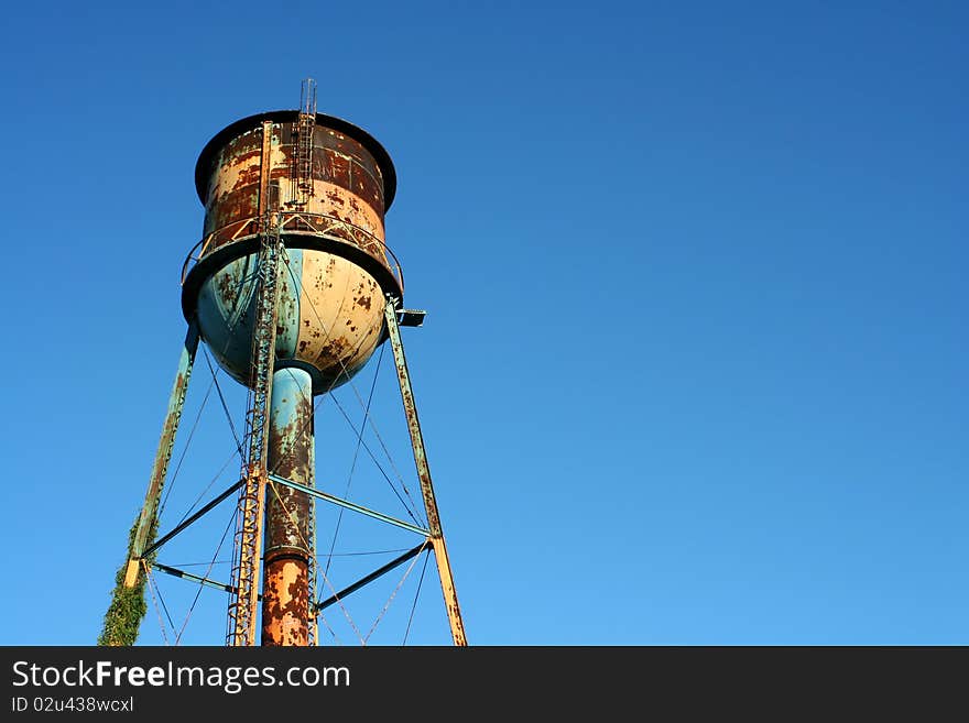 Old rusty watertower against blue sky