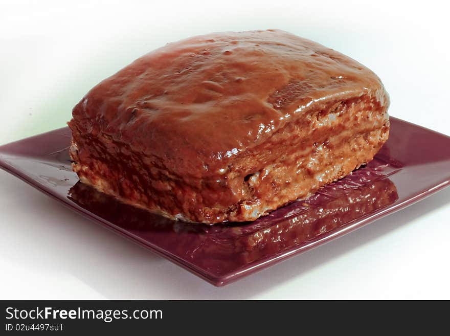 Poppyseed cake with chocolate topping on rectangular plate. Poppyseed cake with chocolate topping on rectangular plate