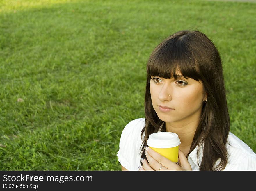 Beautiful girl in the park with coffee