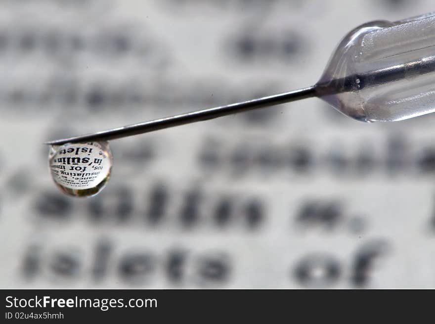 Insulin reflected in insulin drop from syringe needle. Insulin reflected in insulin drop from syringe needle