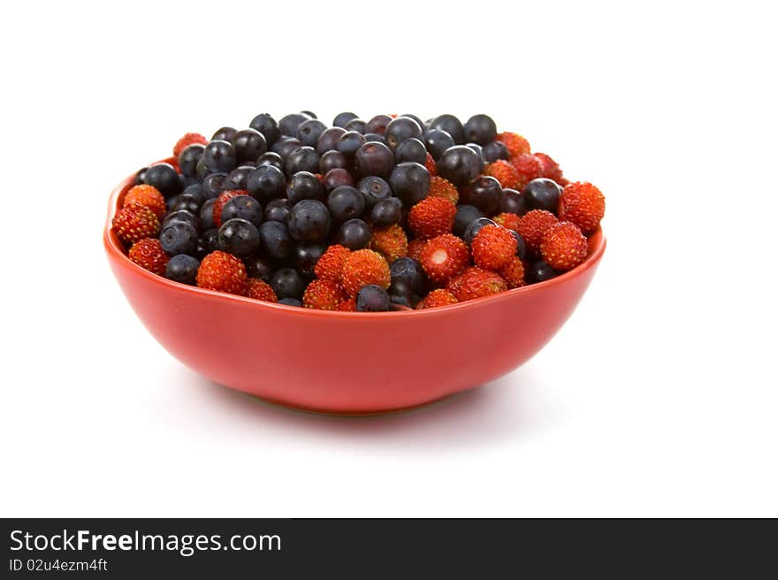 Wild strawberries and blueberries on a white background