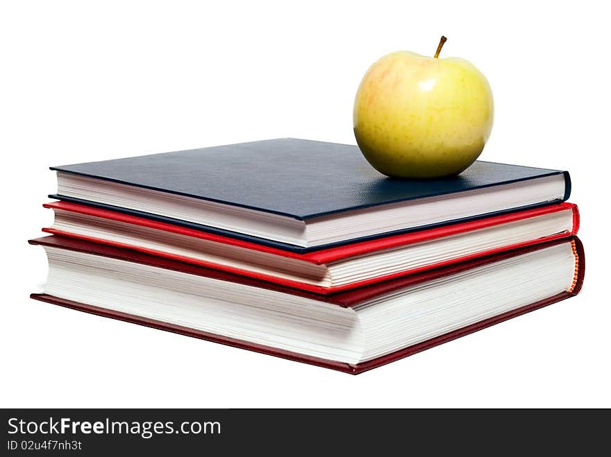 Stack of books and green apple on a white background