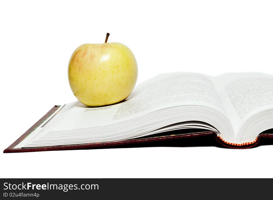 Open book and green apple on a white background