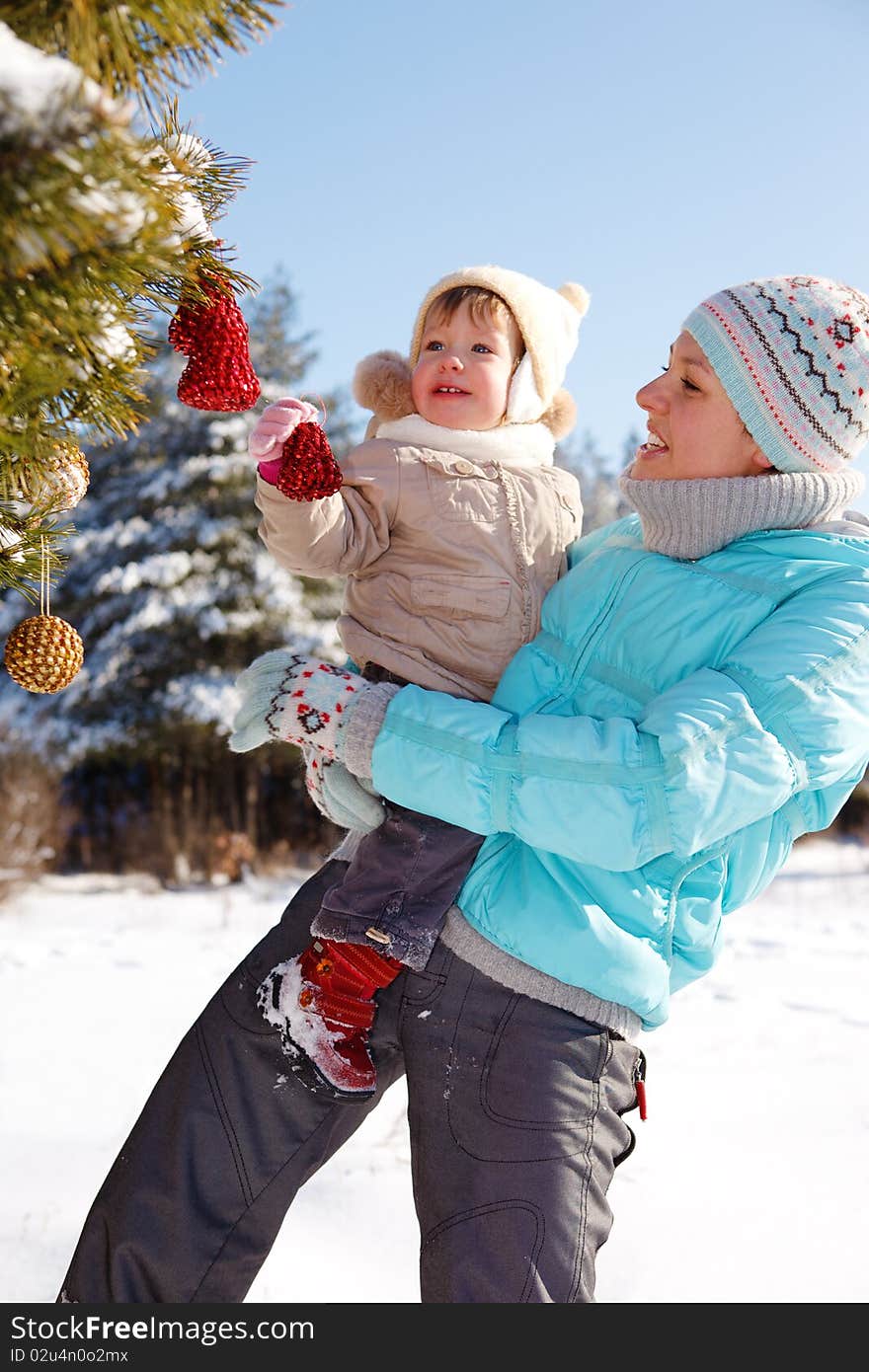 Mother and toddler girl decorating Christmas tree