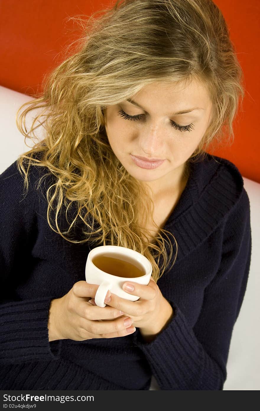 Young woman drinking tea while sitting on the couch. Young woman drinking tea while sitting on the couch