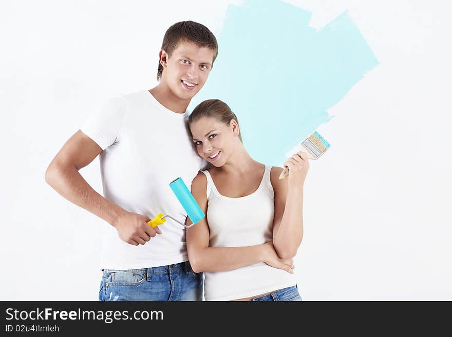 Young attractive couple on the background of painted wall. Young attractive couple on the background of painted wall