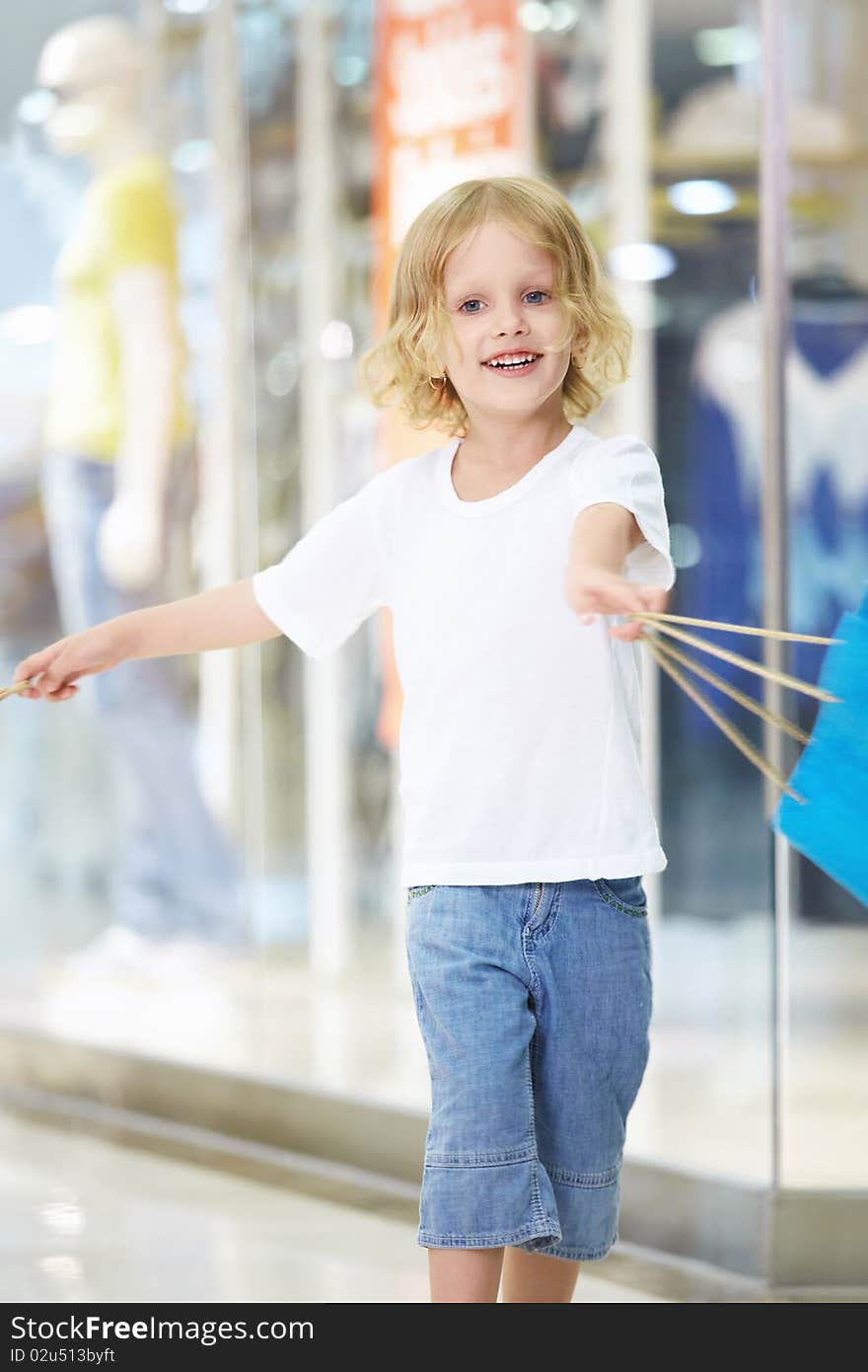 The little girl waving a bag in the store. The little girl waving a bag in the store