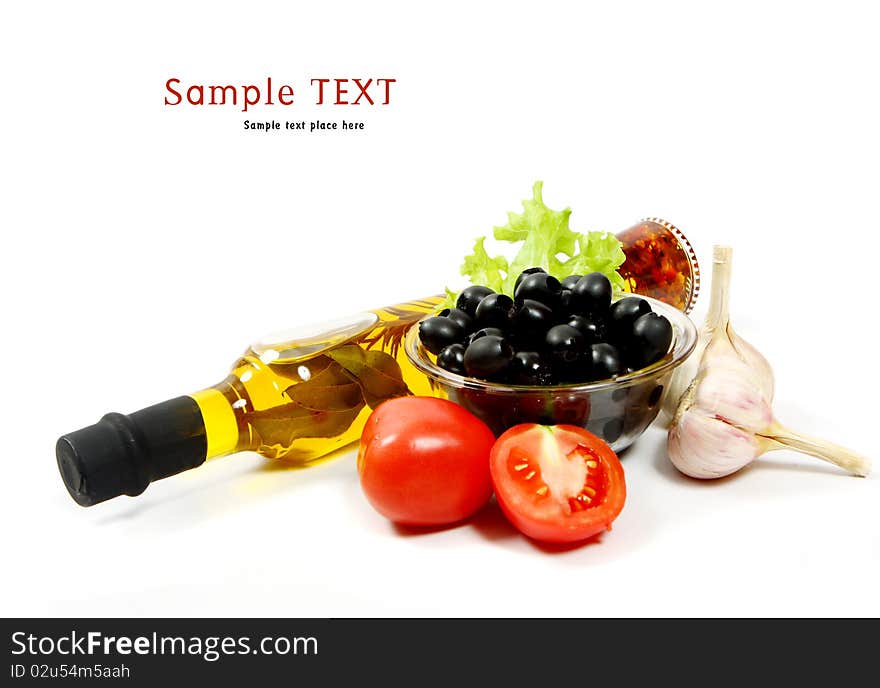 A bottle of olive oil with pasta and black olives isolated on a white background.