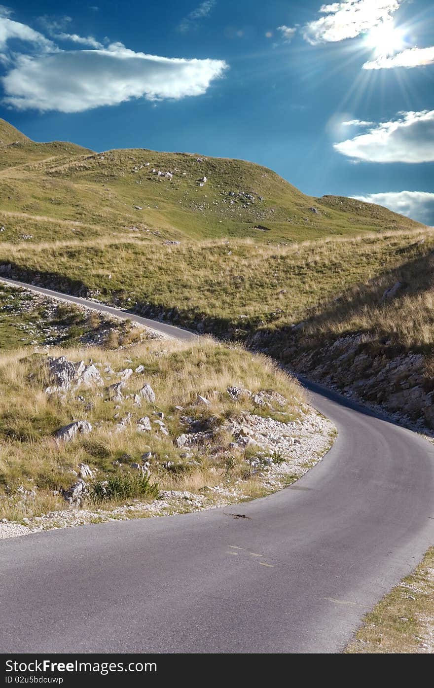 Asphalt road in mountains, sunny weather