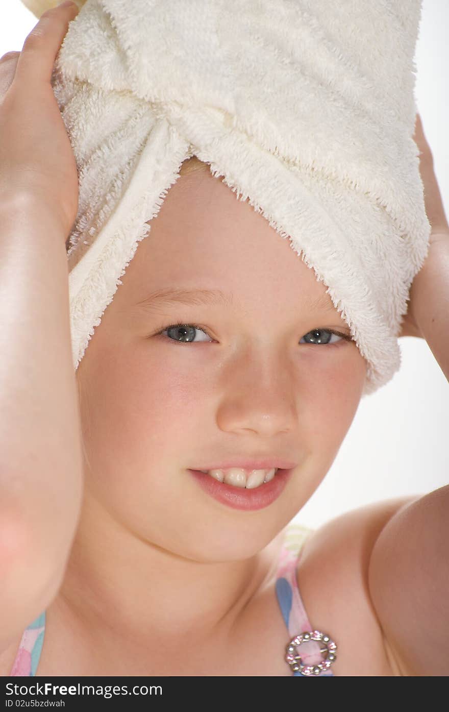 Young girl smiling and looking into the camera with a towel wrapped around her wet hair. Young girl smiling and looking into the camera with a towel wrapped around her wet hair