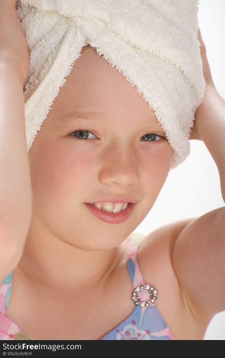 Young girl smiling and looking into the camera with a towel wrapped around her wet hair. Young girl smiling and looking into the camera with a towel wrapped around her wet hair