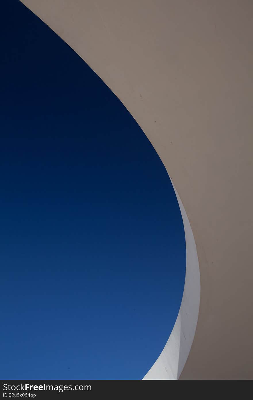 Suspended curved concrete walkway against blue sky. Suspended curved concrete walkway against blue sky