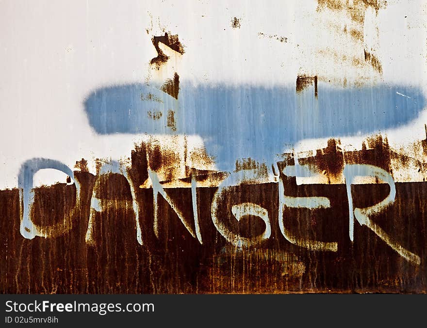 Grunge danger sign spray painted on a wall. Grunge danger sign spray painted on a wall