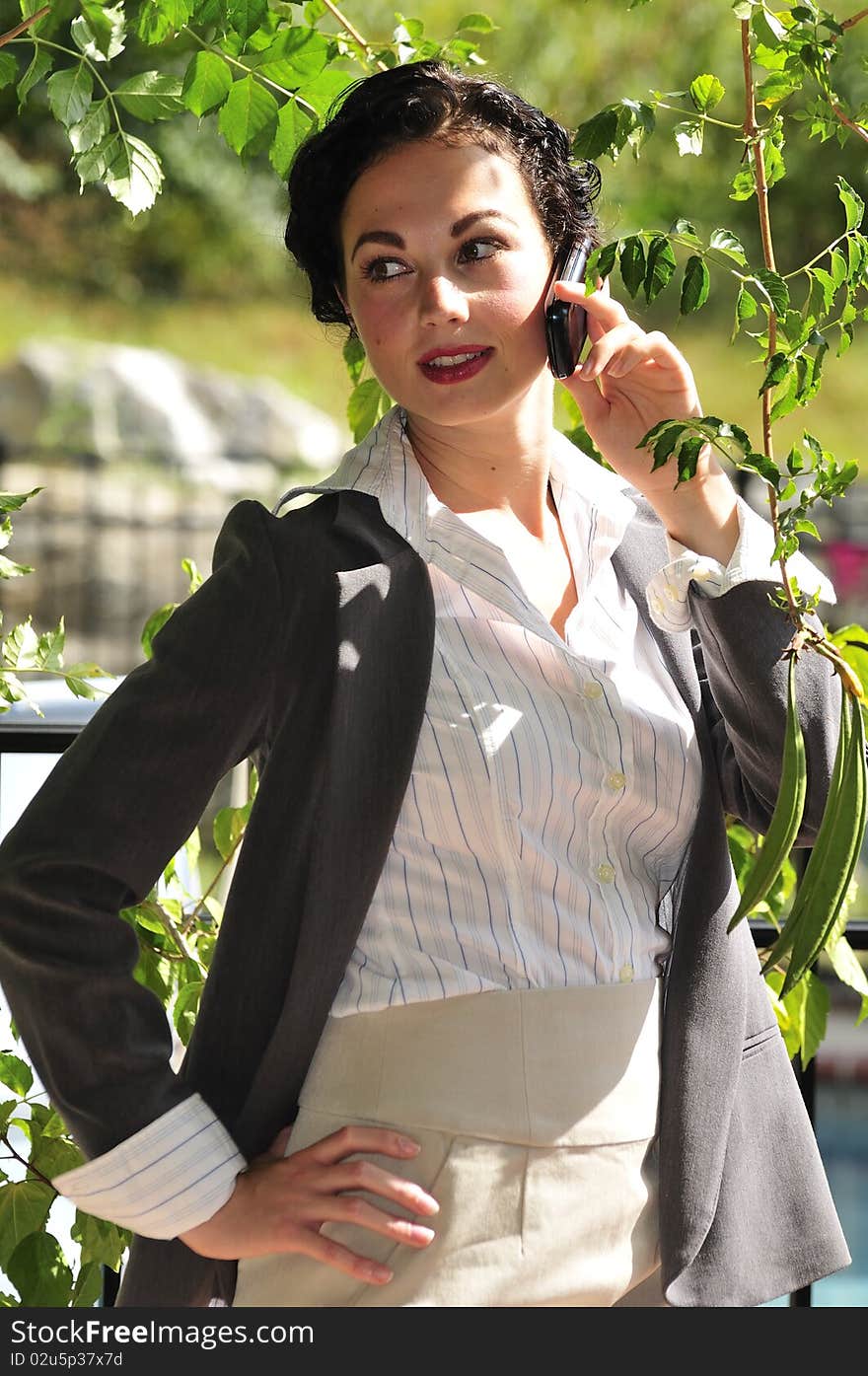 Attractive business woman talking on the cell phone outside. Attractive business woman talking on the cell phone outside