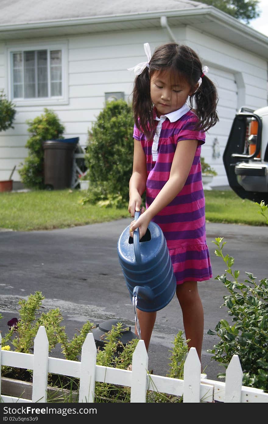 Asian girl watering flowers