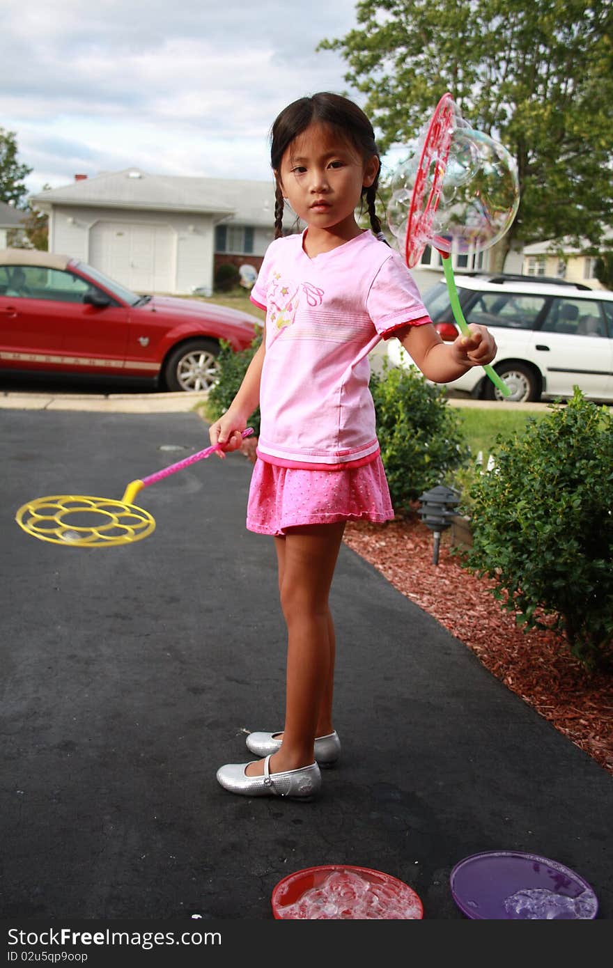 Cute Asian girl playing with a bubble wand. Cute Asian girl playing with a bubble wand.