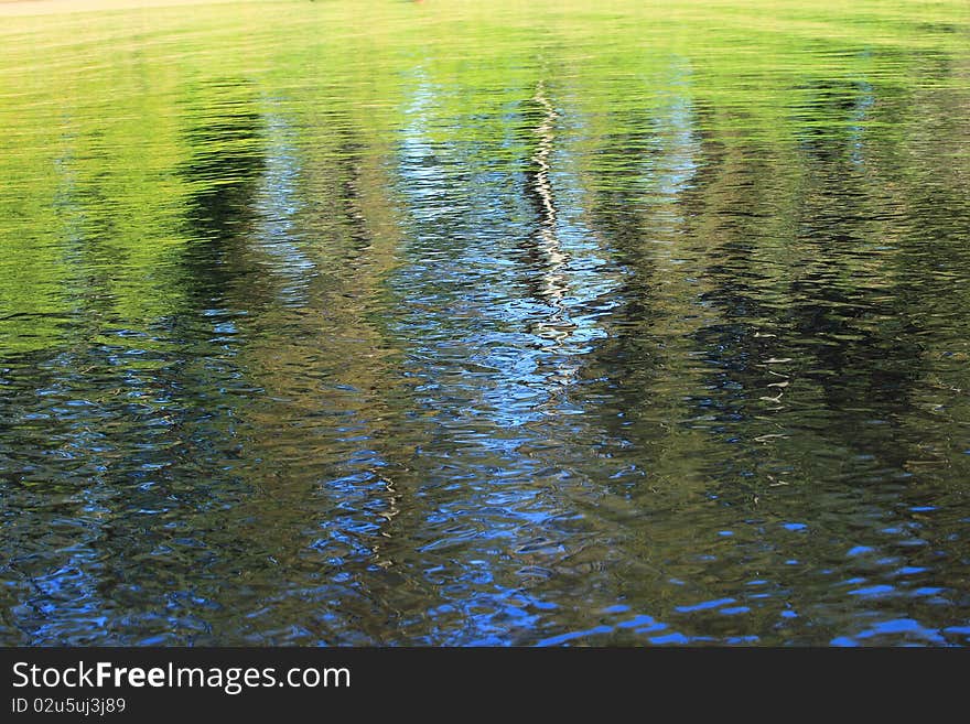 A reflective river's bank on a sunny day. A reflective river's bank on a sunny day.