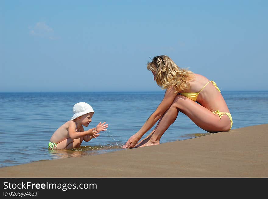 Mother with child plays on the beach