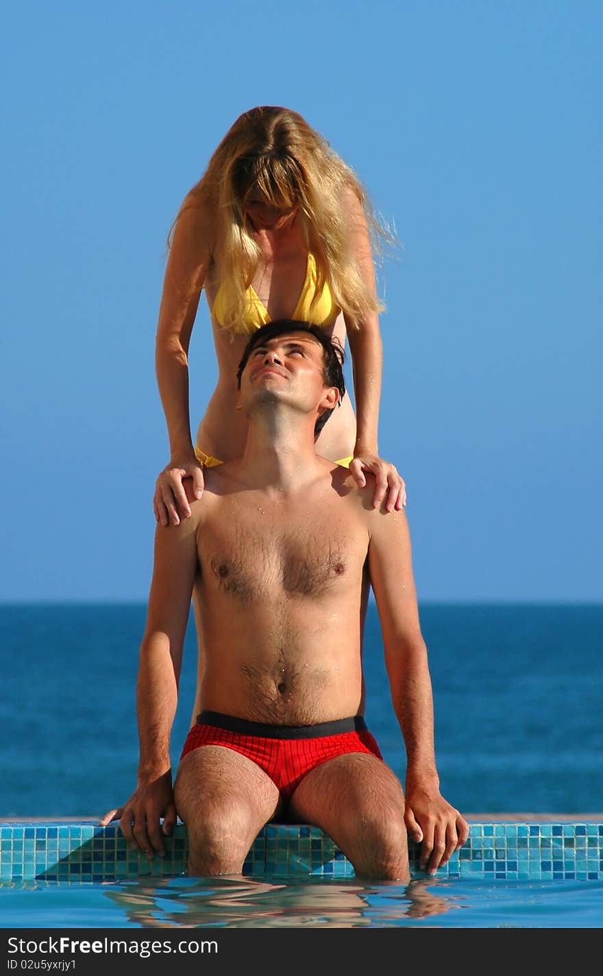 The young woman and man beside water pool