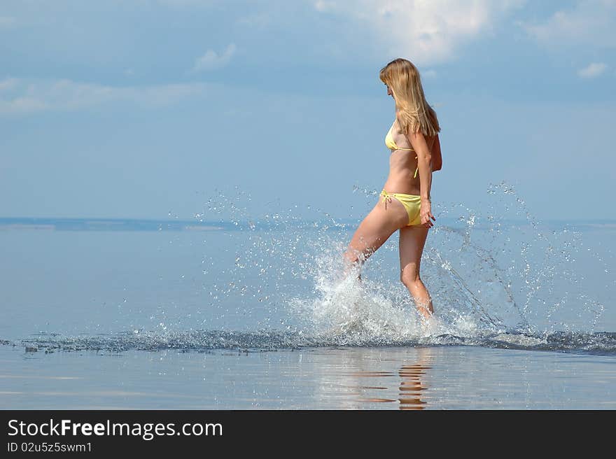 Young woman in bikini splash on water