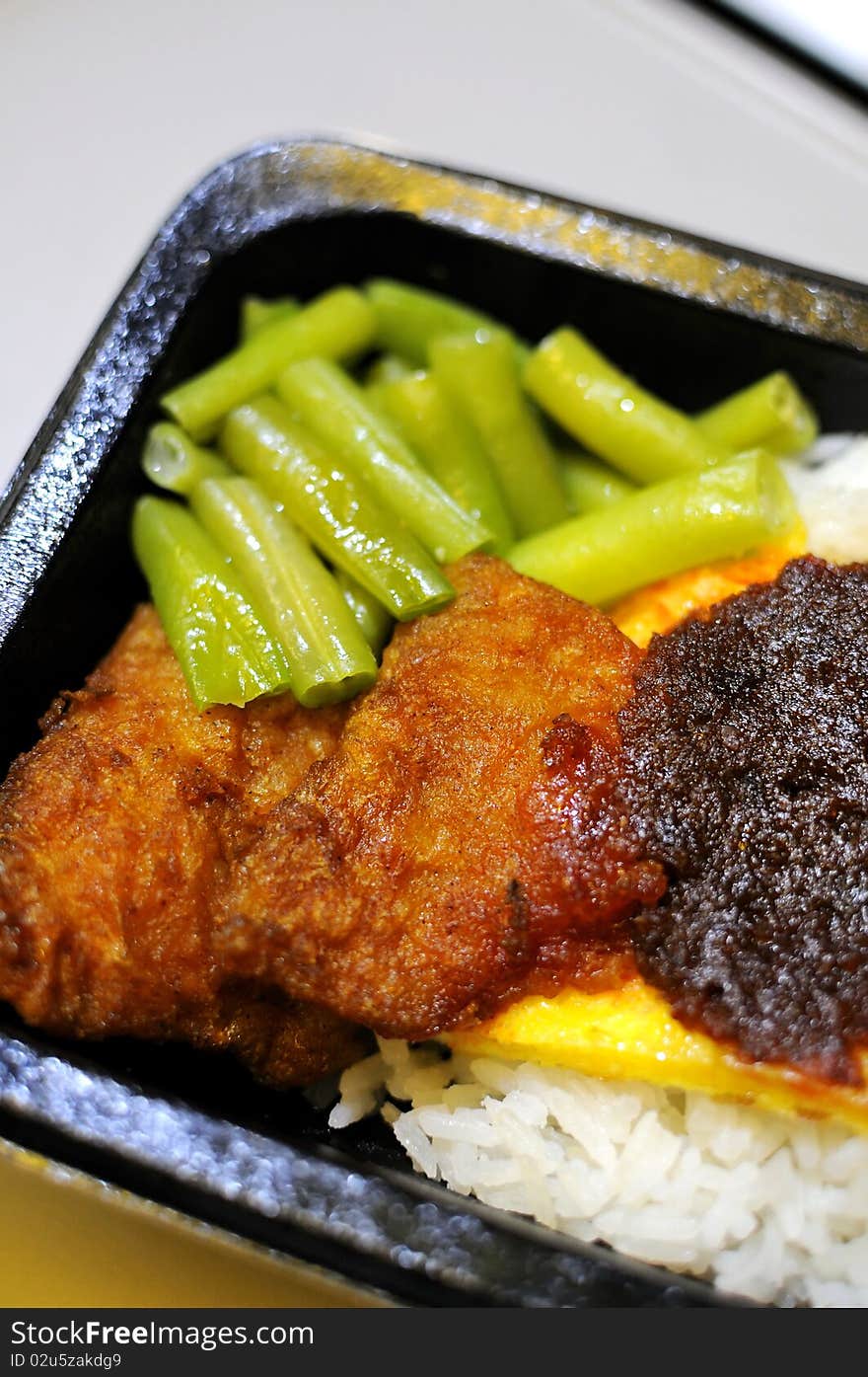 Malay rice set meal with fried fish cutlets. Concepts such as food and beverage, and travel and cuisine, and health and nutrition. Malay rice set meal with fried fish cutlets. Concepts such as food and beverage, and travel and cuisine, and health and nutrition.