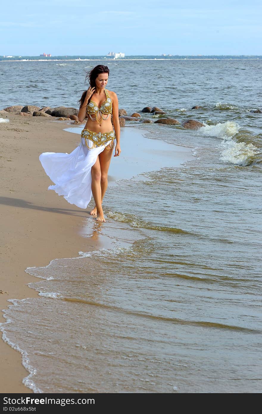 Beautiful young girl walking on beach