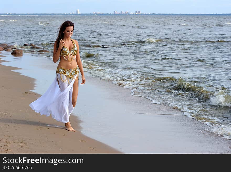 Beautiful young girl walking on the beach