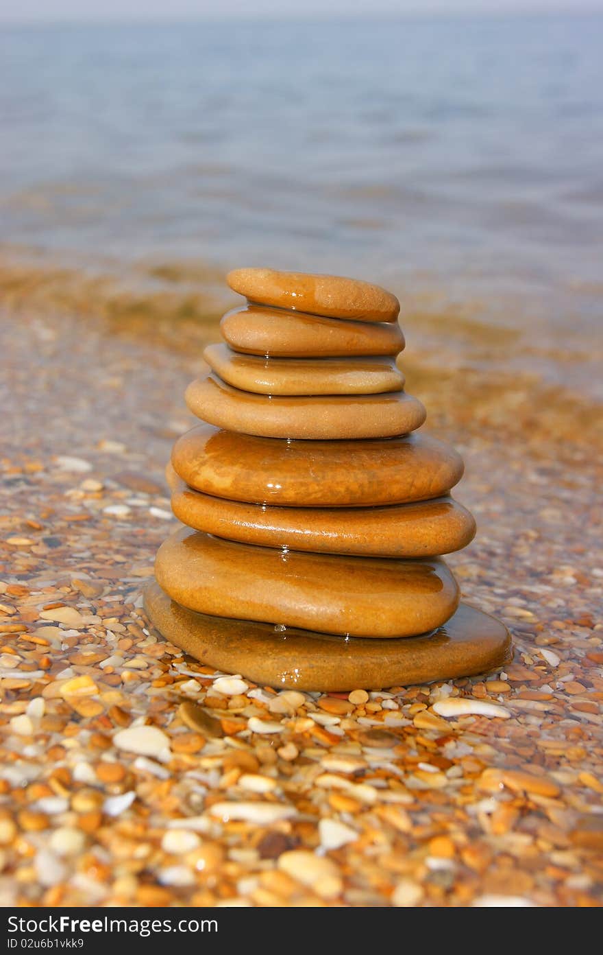 Stones on seacoast. A pyramid from stones. Flat sea stones. A pyramid on a beach.