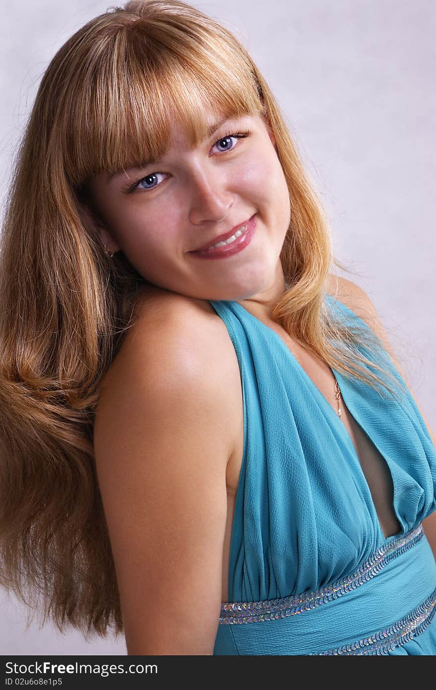 Girl in a blue long dress on a light grey background