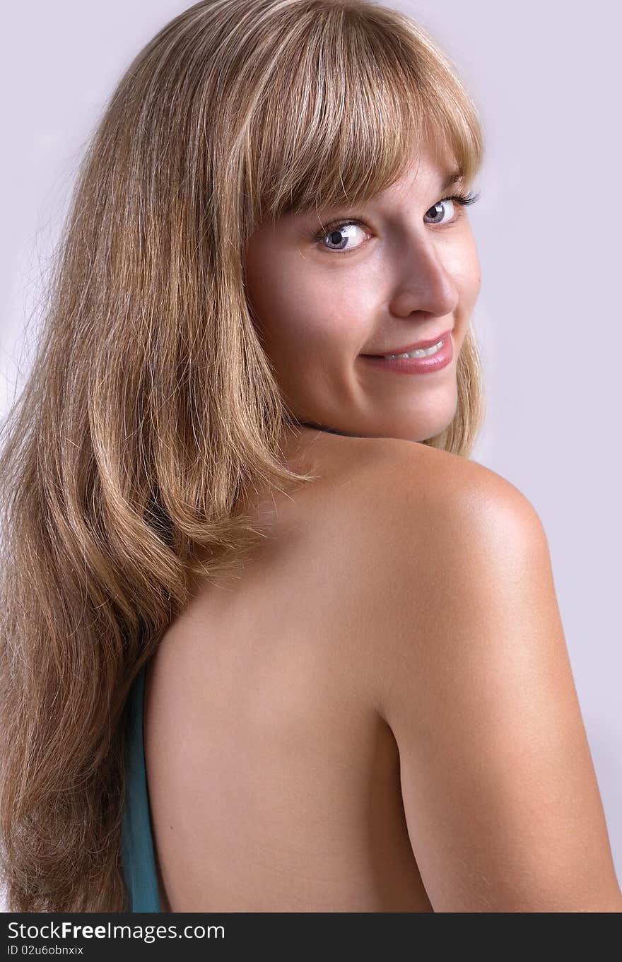 Portrait of the smiling girl on a light grey background