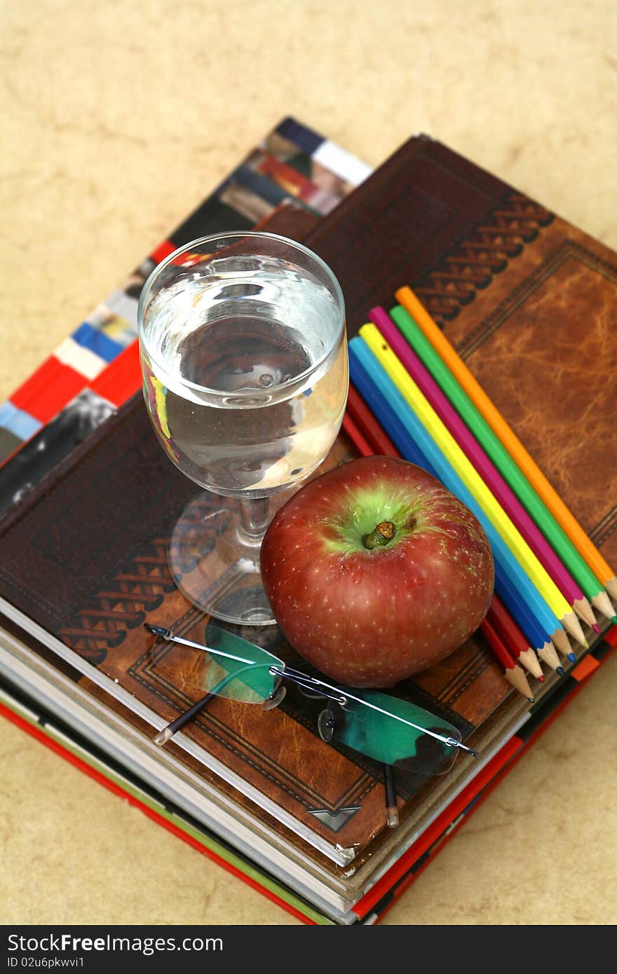 Red apple resting on the book with chalk board as background. Red apple resting on the book with chalk board as background