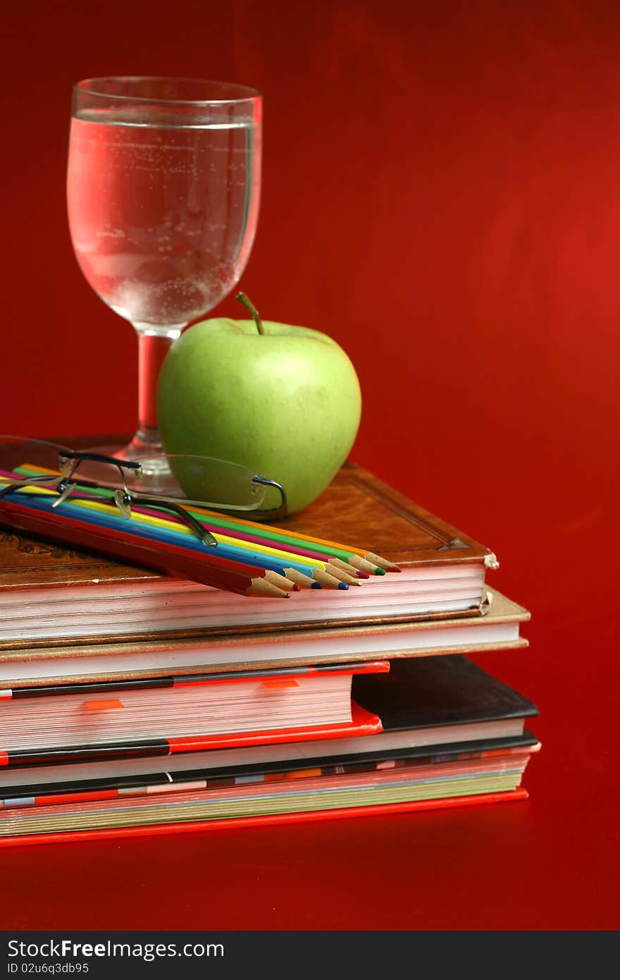 Green apple resting on the book with chalk board as background. Green apple resting on the book with chalk board as background