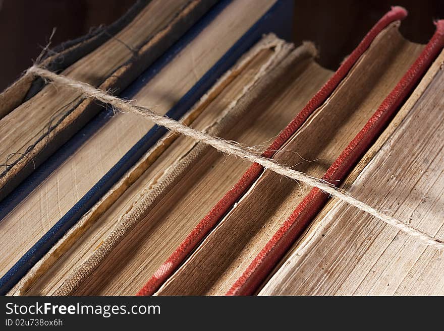 Archival books in a book-depository are tied up by a cord. Archival books in a book-depository are tied up by a cord.