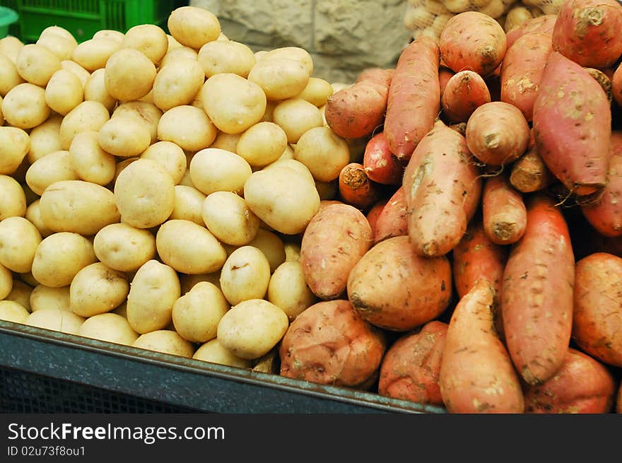 White and sweet potatoes on market stand