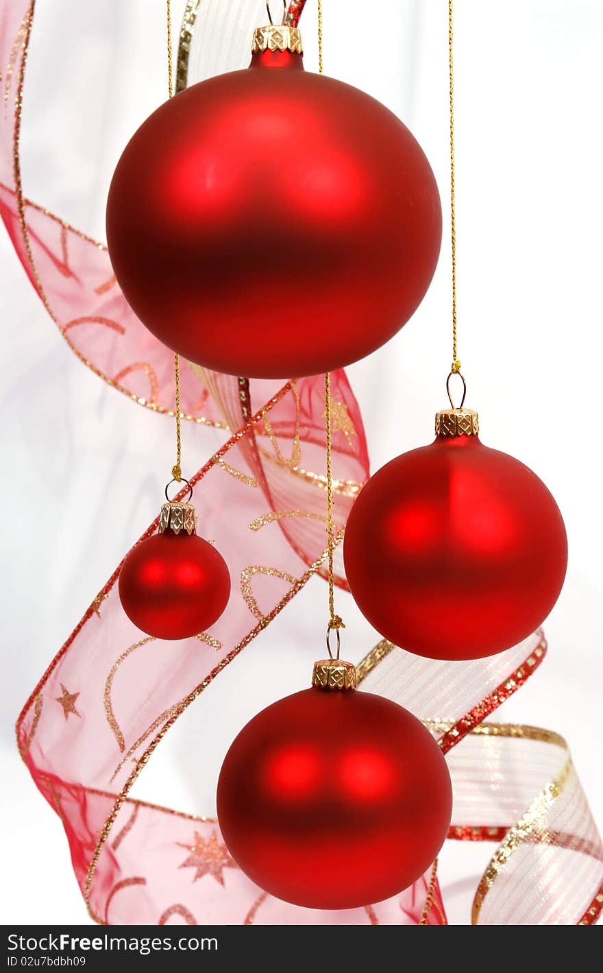 Hanging red glass balls with the ribbon on the white background. Hanging red glass balls with the ribbon on the white background